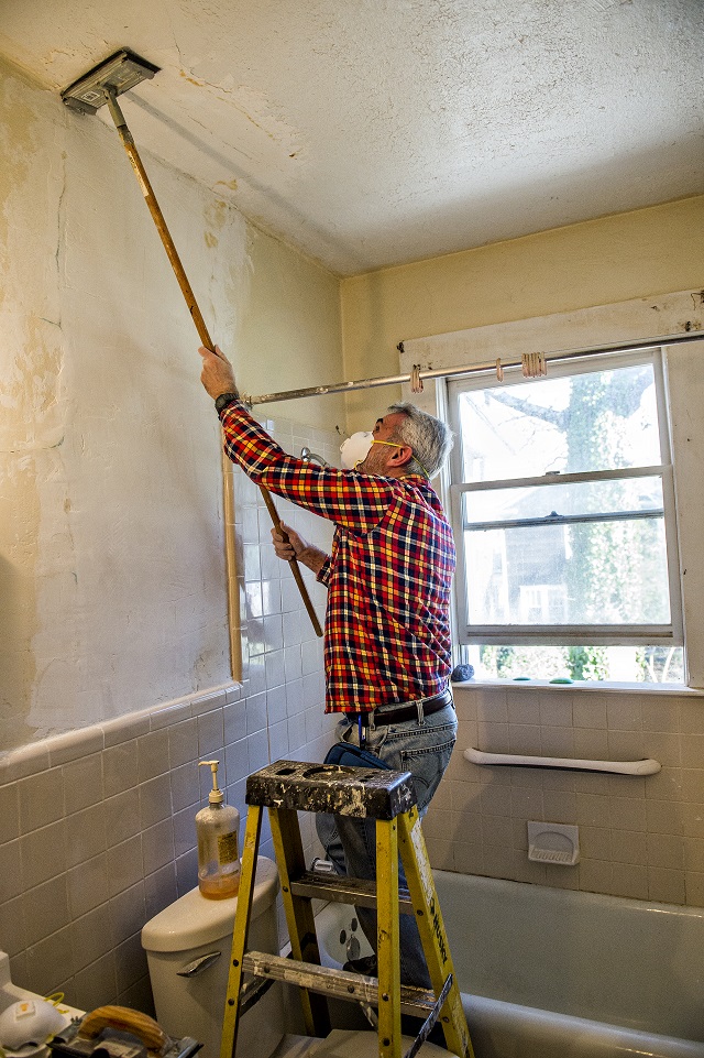 Chuck Warner works to remove paint at one of the 33 houses in Decatur during the 14th annual Martin Luther King Jr. Service Project on Sunday. Photo: Jonathan Phillips