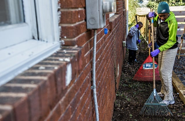 Selina McGill (right) and her brother Joseph rake up debris at one of the 33 houses in Decatur during the 14th annual Martin Luther King Jr. Service Project on Sunday. Photo: Jonathan Phillips