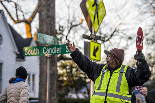 Maurice Johnson (right) stops traffic at the intersection of S. Candler and E. Dougherty streets in Decatur so people can cross on their way to school during the Big Walk on South Candler event on Wednesday morning. Photo: Jonathan Phillips