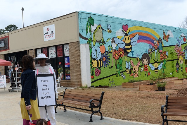 Deborah Palmer talks to a woman passing by the new bee mural in Oakhurst. Photo by Dan Whisenhunt