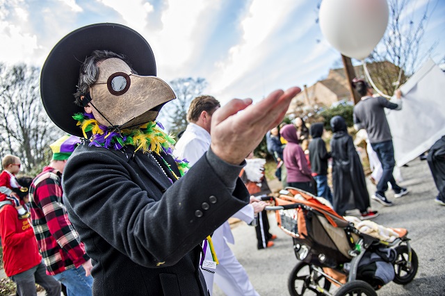 Dan Payne (left) tosses beads to the crowd during the Mead Rd. Mardi Gras Parade on Saturday. Photo: Jonathan Phillips