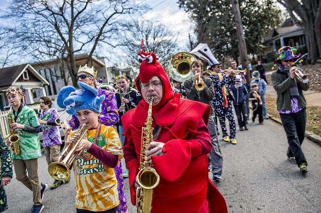 Matt Smith (center) plays his saxophone during the Mead Rd. Mardi Gras Parade on Saturday. Photo: Jonathan Phillips