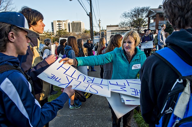 Bailey Pendergrast (center) hands out signs to people in the crowd gathered across from Decatur High School during the Rally for Riley on Monday morning. Photo: Jonathan Phillips