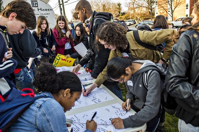 Supporters of Susan Riley crowd around a table to write her letters during the Rally for Riley across from Decatur High School on Monday morning. Photo: Jonathan Phillips