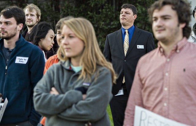 City Schools of Decatur Superintendent Dr. David Dude (center) listens to people speak during the Rally for Riley across from Decatur High School on Monday morning. Dude is reconsidering his decision to terminate Susan Riley, a popular media clerk at Decatur High School. Photo: Jonathan Phillips