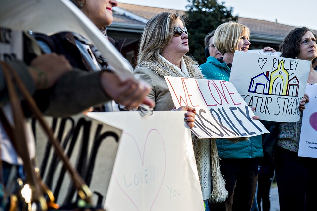 Caroline Grimes (center) holds a sign in support of Susan Riley during the Rally for Riley across from Decatur High School on Monday morning. Photo: Jonathan Phillips