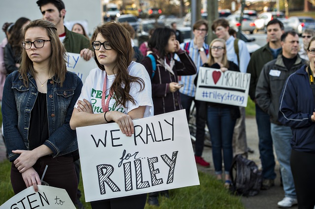 Braylen Dixon (left) and Abigail Gasparotti hold signs while they listen to speakers talk in support of Susan Riley during the Rally for Riley across from Decatur High School on Monday morning. Photo: Jonathan Phillips