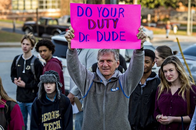 Leonard Thibadeau (center) holds a sign above his head during the Rally for Riley across from Decatur High School on Monday morning. Photo: Jonathan Phillips