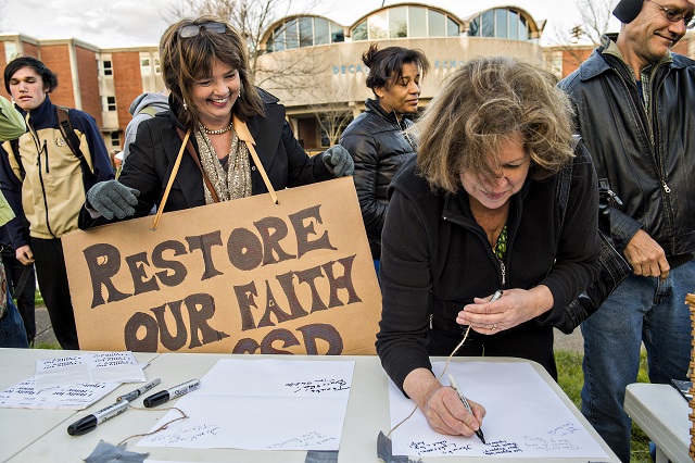 Mary Rigger (left) and Lynne Norman crowd around a table to write Susan Riley letters during the Rally for Riley across from Decatur High School on Monday morning. Photo: Jonathan Phillips