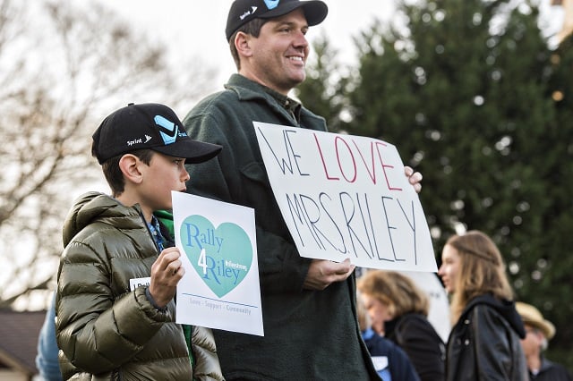 Isaiah Lewis (left) and his father Jeremy hold signs in support of Susan Riley as they stand across from Decatur High School during the Rally for Riley on Monday morning. Photo: Jonathan Phillips