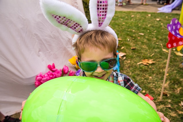 Sam Rogers plays with a giant green egg after the Easter egg hunt.