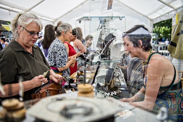 Leslie Ferrill (left) pays Susan Saul for a piece of jewelry during the Decatur Arts Festival on Saturday. Photo: Jonathan Phillips