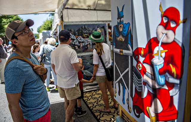 Alex Truong (left) checks out Justin Vowell's artwork Aaron Collier's artwork during the Decatur Arts Festival on Saturday. Photo: Jonathan Phillips