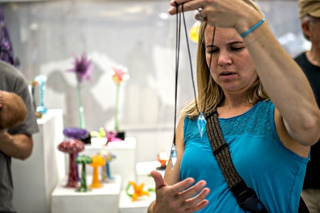 Julie Schuman looks at glass pendants during the Decatur Arts Festival on Saturday. Photo: Jonathan Phillips