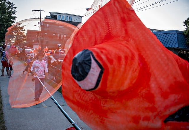 Dave Lind (left) moves his goldfish lantern into position as he waits for the start of the third annual Decatur Lantern Parade on Friday. Photo: Jonathan Phillips