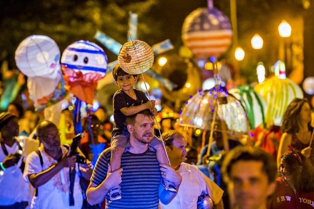 Nyle Corey (center) rides on his father Alan's shoulders during the third annual lantern parade on Friday. Photo: Jonathan Phillips