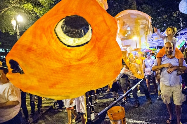Brian Logan (right) carries his daughter Drew on his shoulders as they enter Decatur Square during the third annual lantern parade on Friday. Photo: Jonathan Phillips