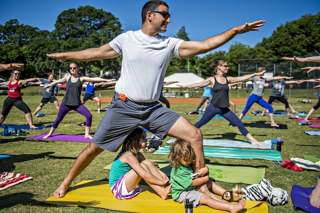 Jean Jacque Credi practices yoga as his children Eve and Edison hang at his feet during the Kirkwood Spring Fling on Saturday. Photo: Jonathan Phillips