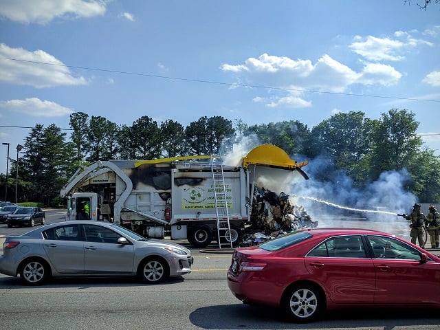 A garbage truck unloads trash onto North Druid Hills road after the contents of the truck caught fire on Wednesday afternoon, May 25. Photo by Dan Whisenhunt