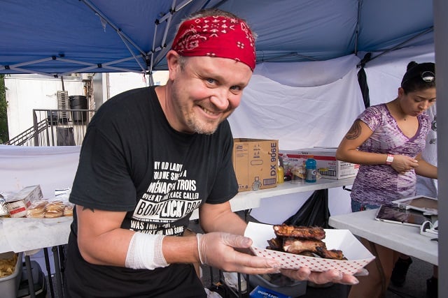 Keiran Neely of Bone Lick BBQ serves customers at the festival. Photo by Steve Eberhardt