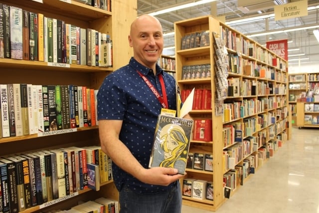 Tony Warmus, Regional Manager for Half Price Books, shows a first edition of "Moonchild" by Aleister Crowley. Photo by Dena Mellick