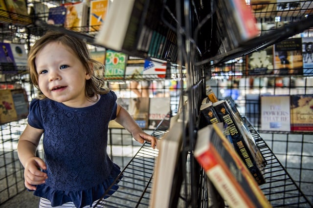 Sabina Uroic plays amongst racks of books during the Decatur Book Festival on Saturday. Photo: Jonathan Phillips