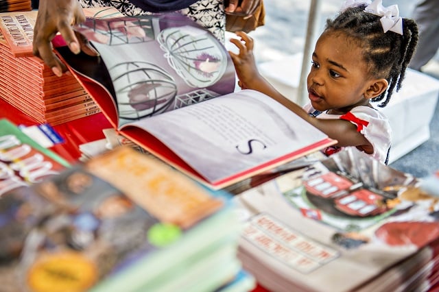 Zendaya Richards flips through the pictures of "The Adventures of Amelia, the Crazy Jumping Hedgehog" during the Decatur Book Festival on Saturday. Photo: Jonathan Phillips