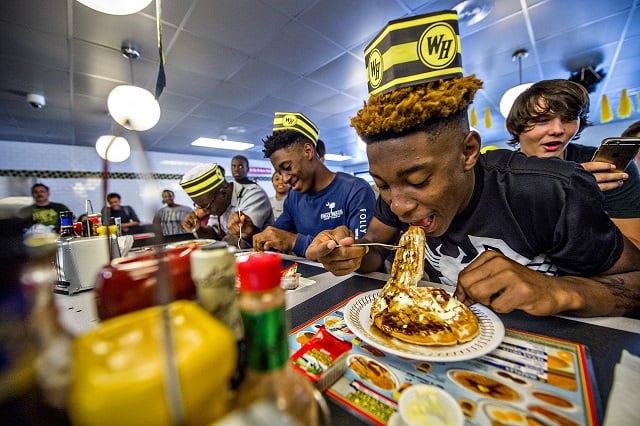 Demetriis Hicks (right) shoves a quarter waffle into his mouth as the waffle eating contest gets underway at the Waffle House off of Decatur Square on Friday. Photo: Jonathan Phillips