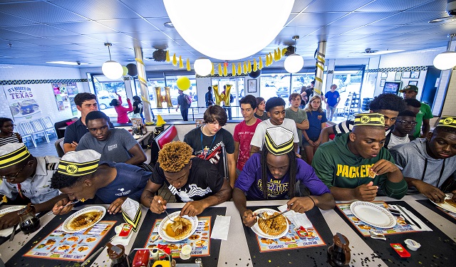 Six contestants participate in the first round of the waffle eating contest at the Waffle House off of Decatur Square on Friday. Photo: Jonathan Phillips