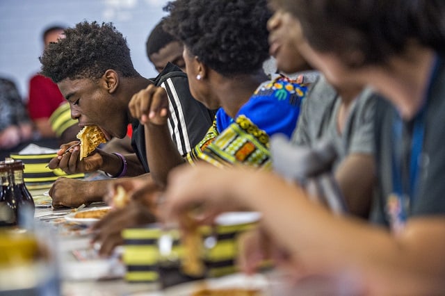 Andre Carter leans over a waffle as he stuffs it in his mouth during the waffle eating contest at the Waffle House off of Decatur Square on Friday. Photo: Jonathan Phillips