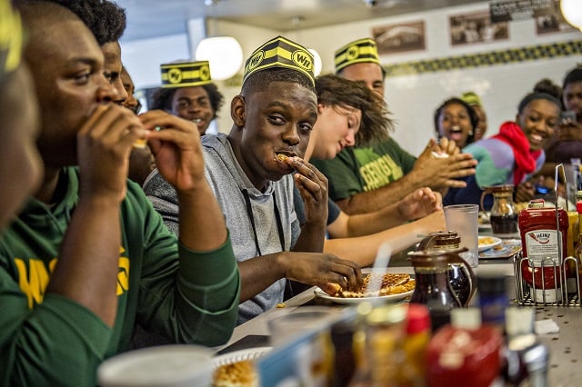 Jonah Wildgoose (center) glances over at Jason McLin as he shoves a waffle into his mouth during the championship round of the waffle eating contest at the Waffle House off of Decatur Square on Friday. Photo: Jonathan Phillips