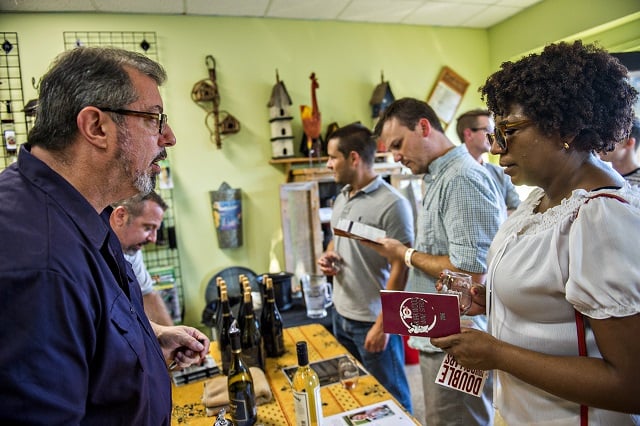 Holly Reid (right) talks with Tom Trainor inside Kirkwood Seed & Feed as he pours wine during the Kirkwood Wine Stroll on Friday. Photo: Jonathan Phillips