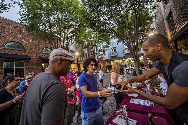 Kevin Wilson (right) pours wine for Jin Lee and Cris Gray during the Kirkwood Wine Stroll on Friday. Photo: Jonathan Phillips