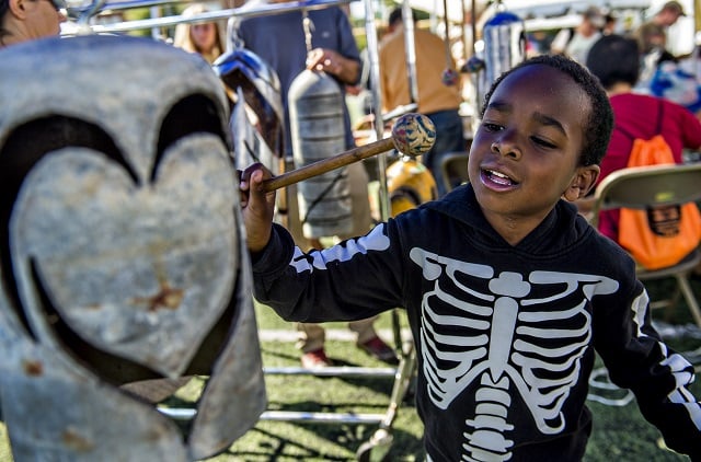 Bryson Powell tries his hand at making music while banging on handmade bells during the Atlanta Maker Faire in Decatur on Saturday. Photo: Jonathan Phillips