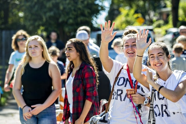 Simone Orr (right) and Grace Tozer-Rich wave to friends as they listen to Tongue Karate perform off of Cambridge Ave. during the annual Oakhurst Porchfest on Saturday. Photo: Jonathan Phillips