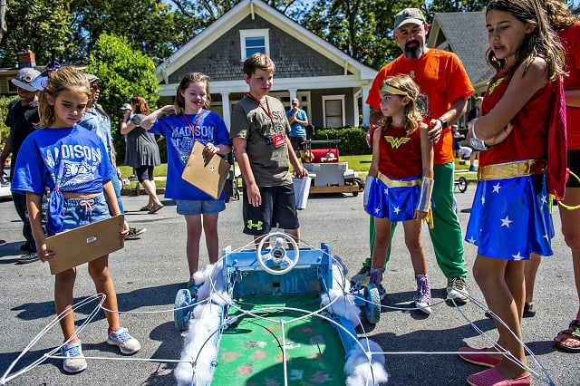 Lola DiCarlo (left), Audrey Trujillo and Wiliiam Roach judge the Team Hall Netherton car as Josh Netherton and his daughters Elizabeth and Penny tak about how they came up with the Wonder Woman theme before the start of the 6th annual Madison Ave. Soapbox Derby in Oakhurst on Saturday. Photo: Jonathan Phillips