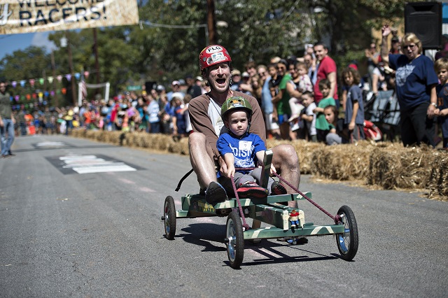 Wyatt Arrington races down the street with his father in tow during the 6th annual Madison Ave. Soapbox Derby in Oakhurst on Saturday. Photo: Jonathan Phillips