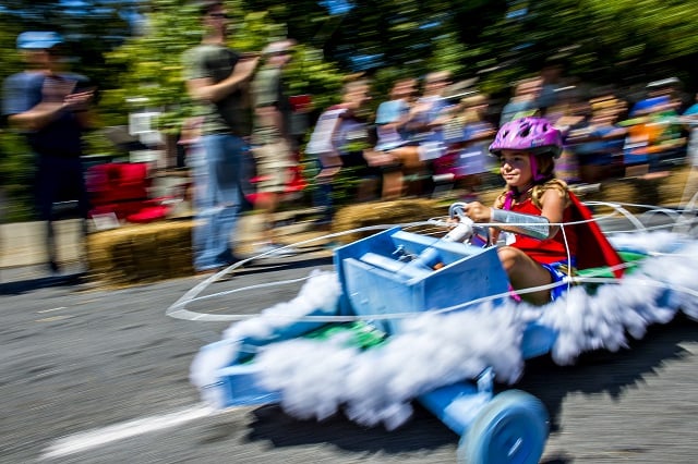 Dressed as Wonder Woman, Penny Netherton steers her invisible jet racer down the street during the 6th annual Madison Ave. Soapbox Derby in Oakhurst on Saturday. Photo: Jonathan Phillips