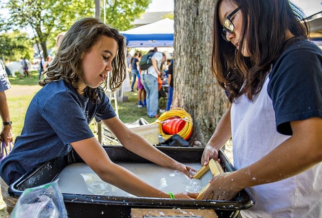 Liliana Sandfort (left) creates a sheet of cotton pulp paper with the help of Christina Lee during the 2016 Atlanta Maker Faire in Decatur on Saturday. Photo: Jonathan Phillips