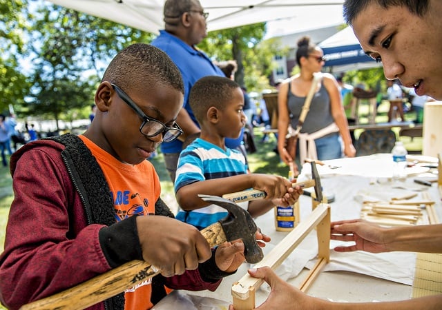 Richmond Doomah (left) and Charles Pierson help Anthony Nguyen build slats for Georgia Tech's urban beehive project during the Atlanta Maker Faire in Decatur on Saturday. Photo: Jonathan Phillips