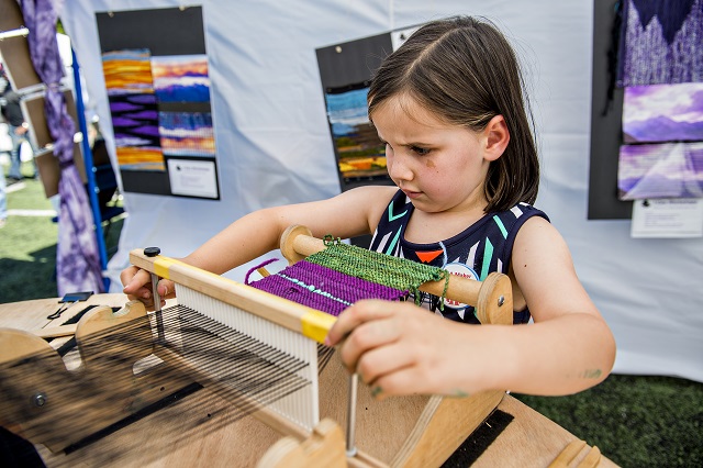 Sonoma Oster tries her hand at weaving during the Atlanta Maker Faire in Decatur on Saturday. Photo: Jonathan Phillips