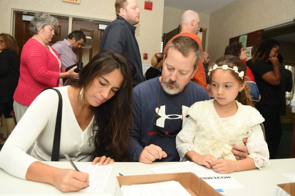 (left to right) Rina Kesler, with her husband, Eddie Kesler and daughter Marina Kesler, fill out paperwork at the Avondale Estates City Hall on November 8, 2016. Rina Kesler just became a citizen of the United States. She says, "I am very excited, very proud and thankful."
