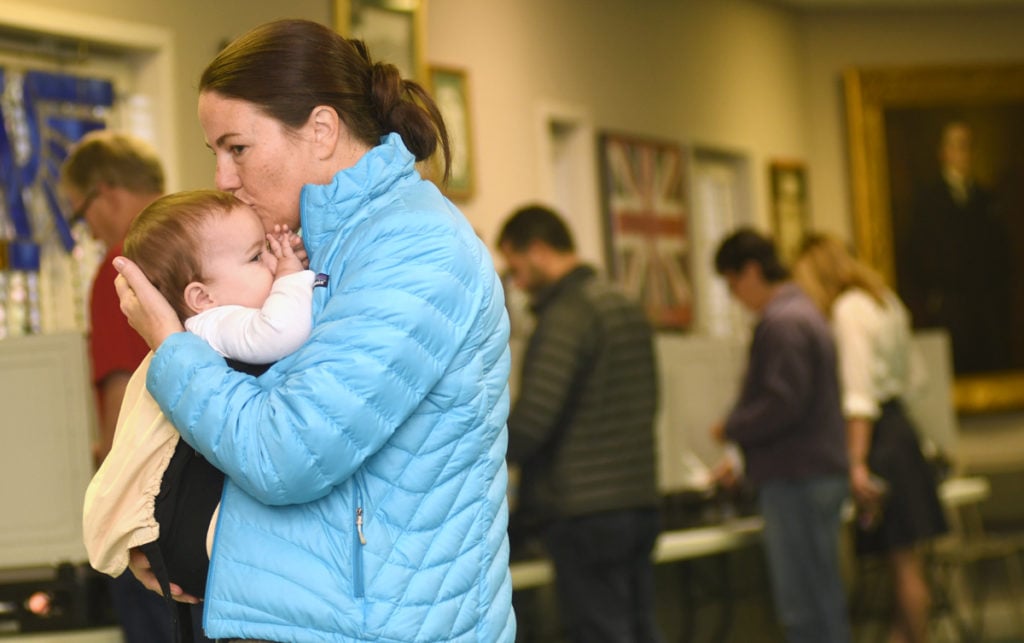 Kimberly Iskandrian and her baby, Roan, 8 months, stand in line at the Avondale Estates City Hall on November 8, 2016. Kimberly says, "We just moved to Avondale. To me, the lines are good."