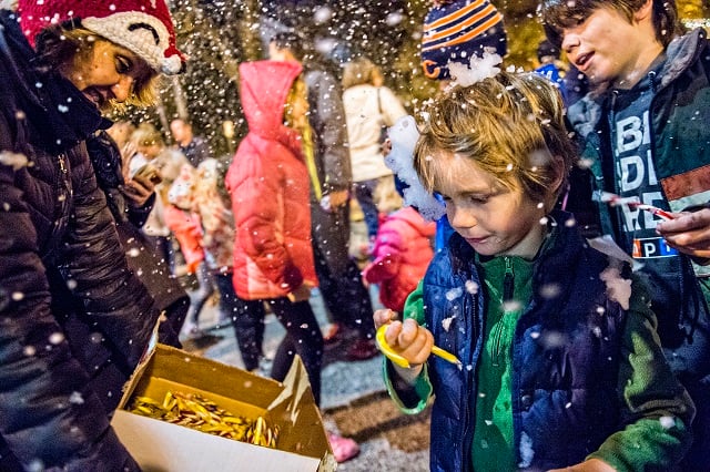 Mary Eadon Robinson (left) passes out candy canes to Jameson Connelly and others during the annual lighting of the tree in Decatur on Thursday. Photo: Jonathan Phillips