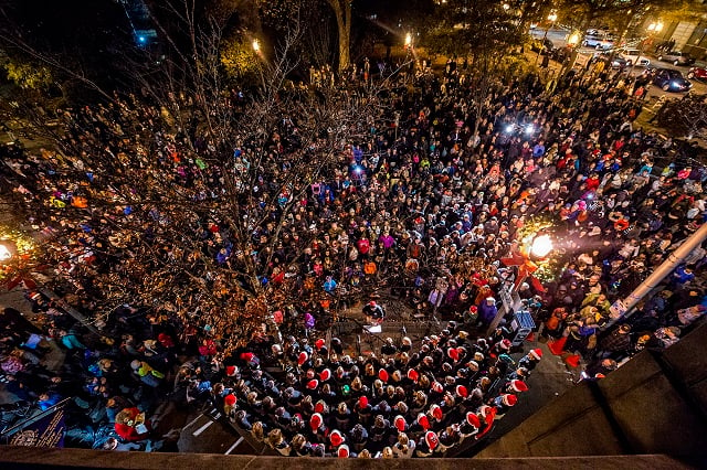 The Voices of Fifth Avenue choir sing Christmas carols as thousands gather in front of Little Shop of Stories during the annual lighting of the tree in Decatur on Thursday. Photo: Jonathan Phillips