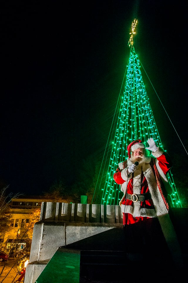 Santa Claus waves to the crowd below after lighting the tree on top of Little Shop of Stories during the annual lighting of the tree in Decatur on Thursday. Photo: Jonathan Phillips