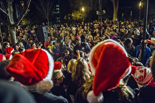 Nick Brooks (center) leads the Voices of Fifth Avenue choir as they sing Christmas carols during the annual lighting of the tree in Decatur on Thursday. Photo: Jonathan Phillips